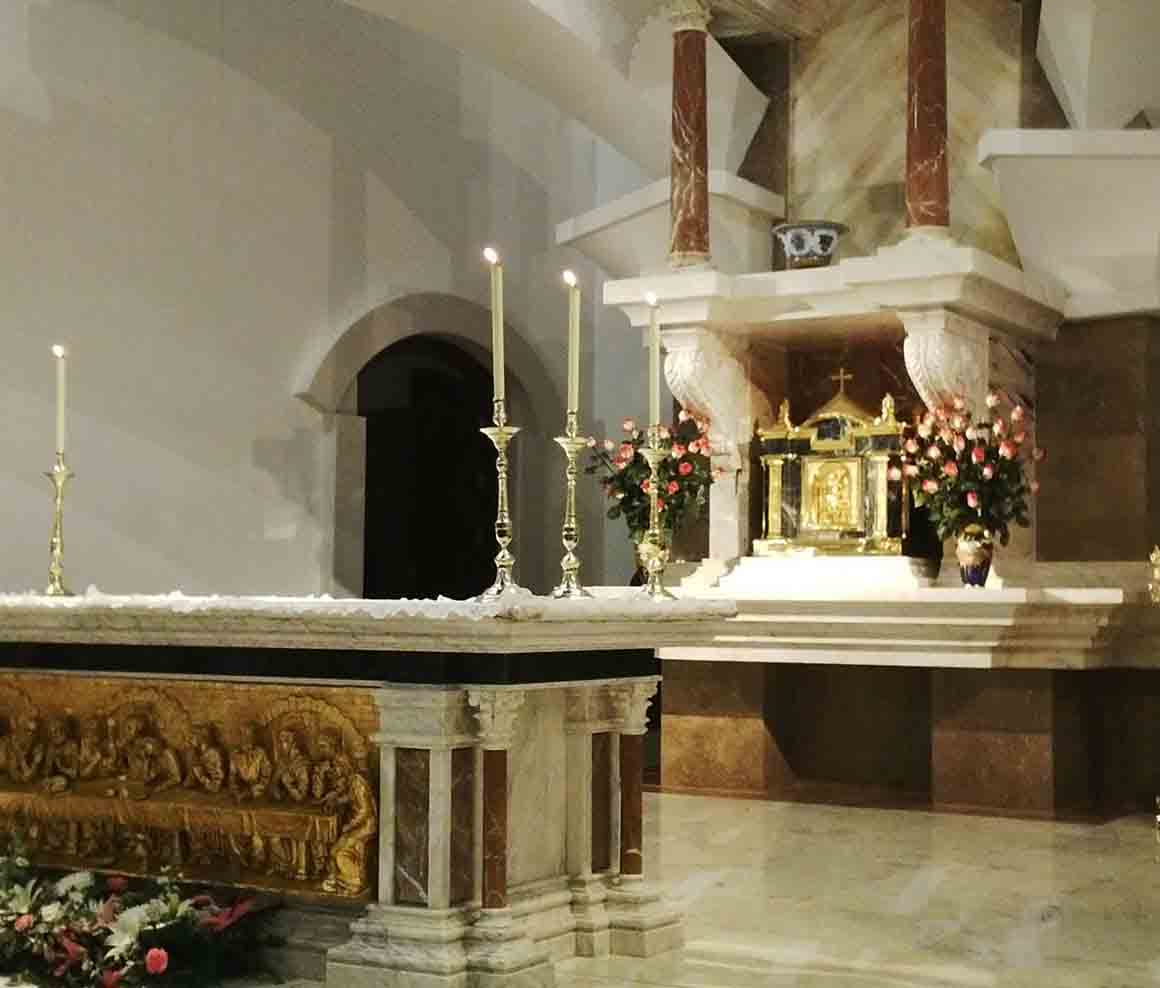 Altar o espacio litúrgico revestido con mármol y elementos ornamentales.