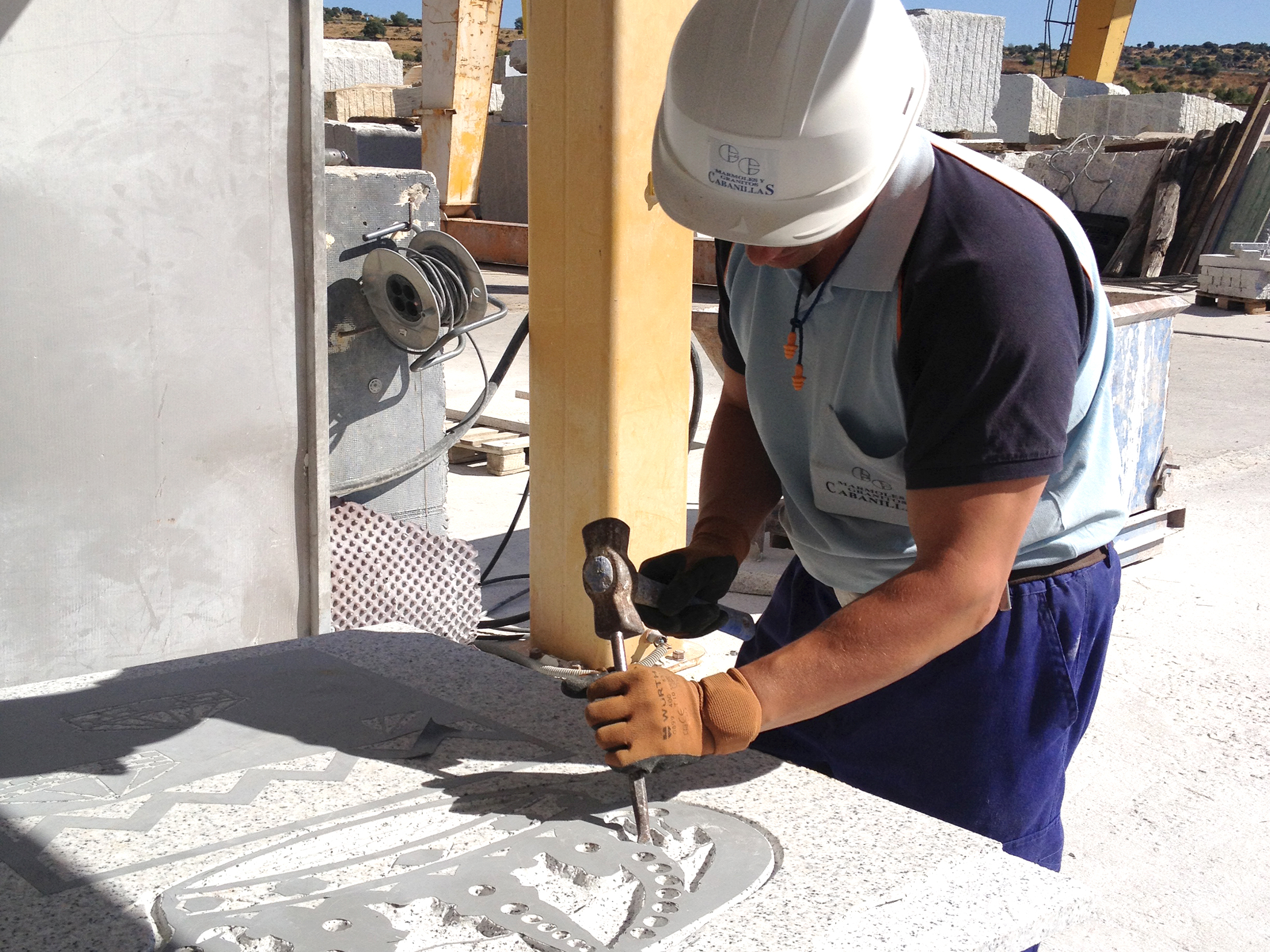 Profesional trabajando y tallando una pieza de piedra.